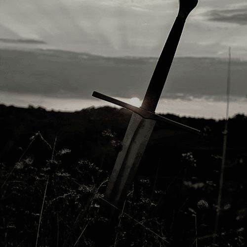 a black and white photo of a cross in the grass