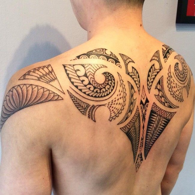 the back of a man's upper half with an intricate tattoo design on it