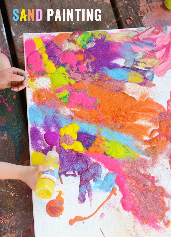 a child is painting with colorful paint on a piece of paper that says sand painting