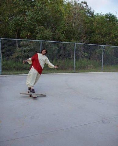 a man riding a skateboard on top of a cement ground next to a fence