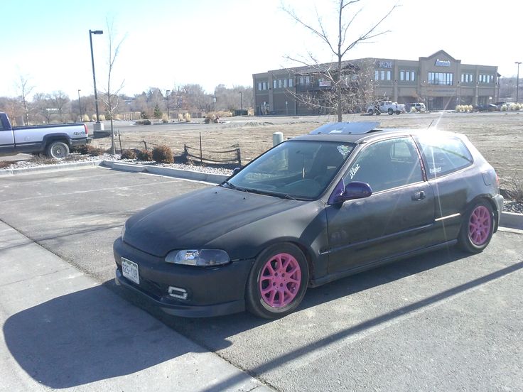 the car is parked on the side of the road in front of a parking lot