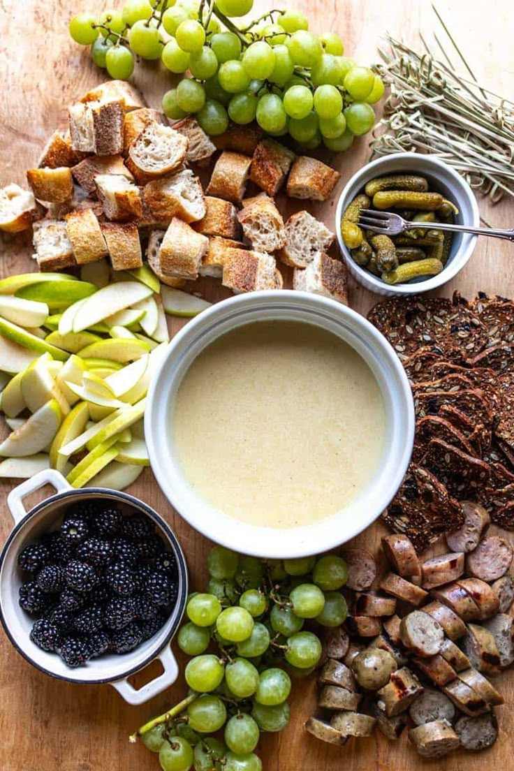 grapes, bread, and other foods are arranged on a table