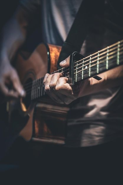 a person playing an acoustic guitar in the dark