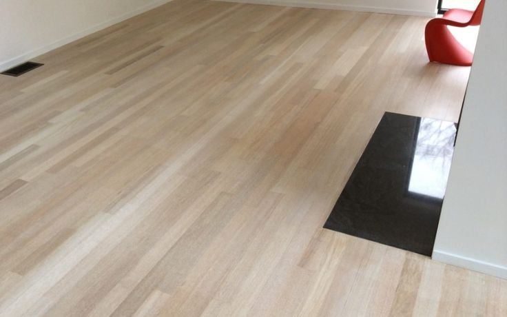 an empty room with hard wood floors and white walls