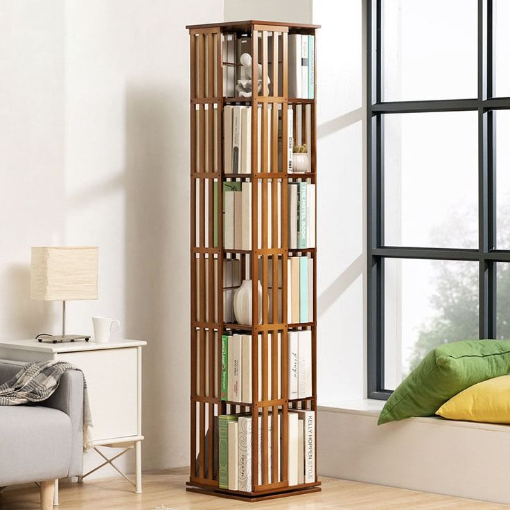 a tall wooden book shelf with books on it in a room next to a window