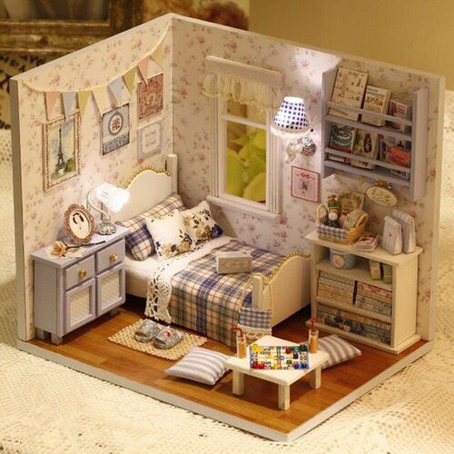 a doll house with a bed and desk in the corner, furniture is arranged around it