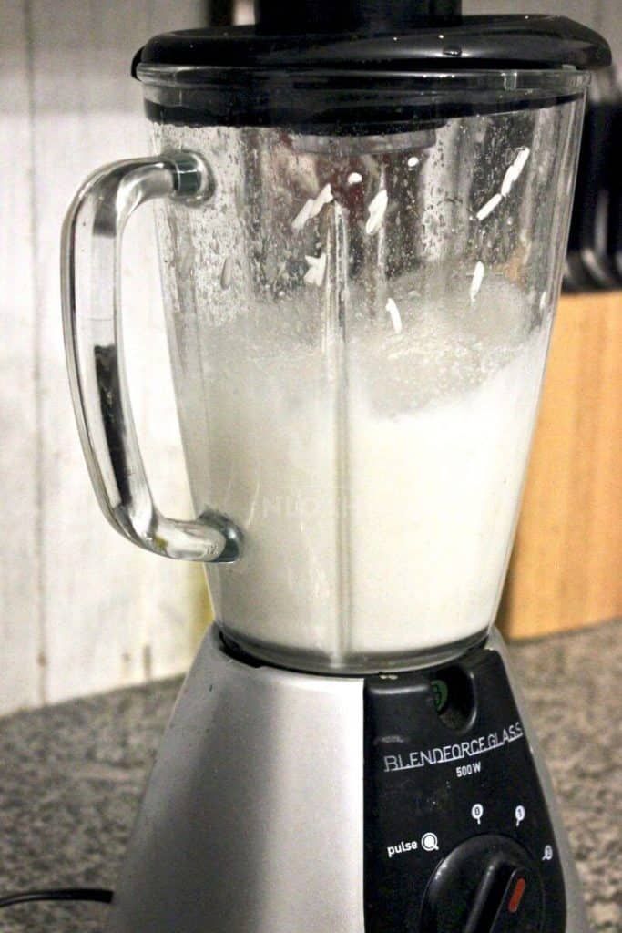 a blender filled with white liquid on top of a counter