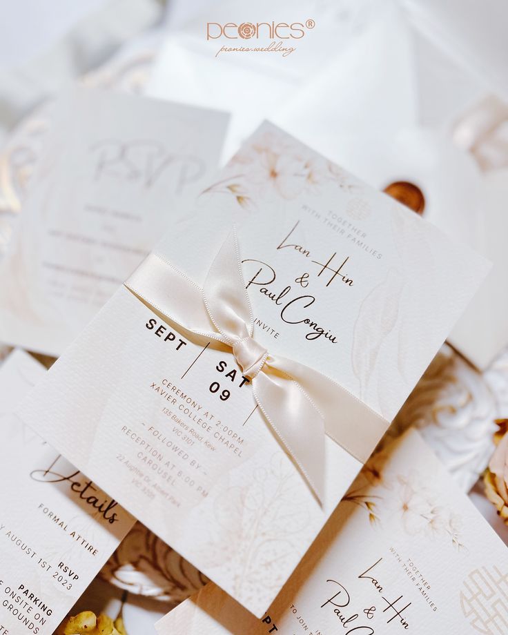 the wedding stationery is laid out on top of each other with ribbons and bows