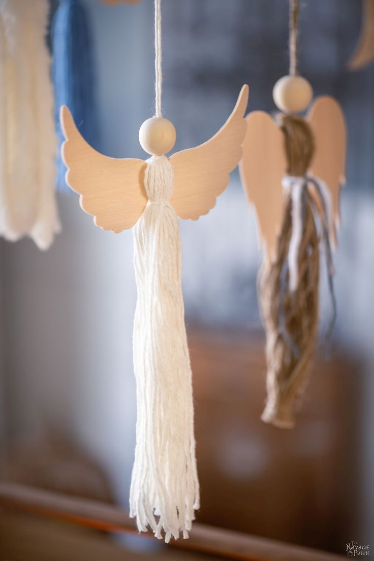 two wooden angel ornaments hanging from strings