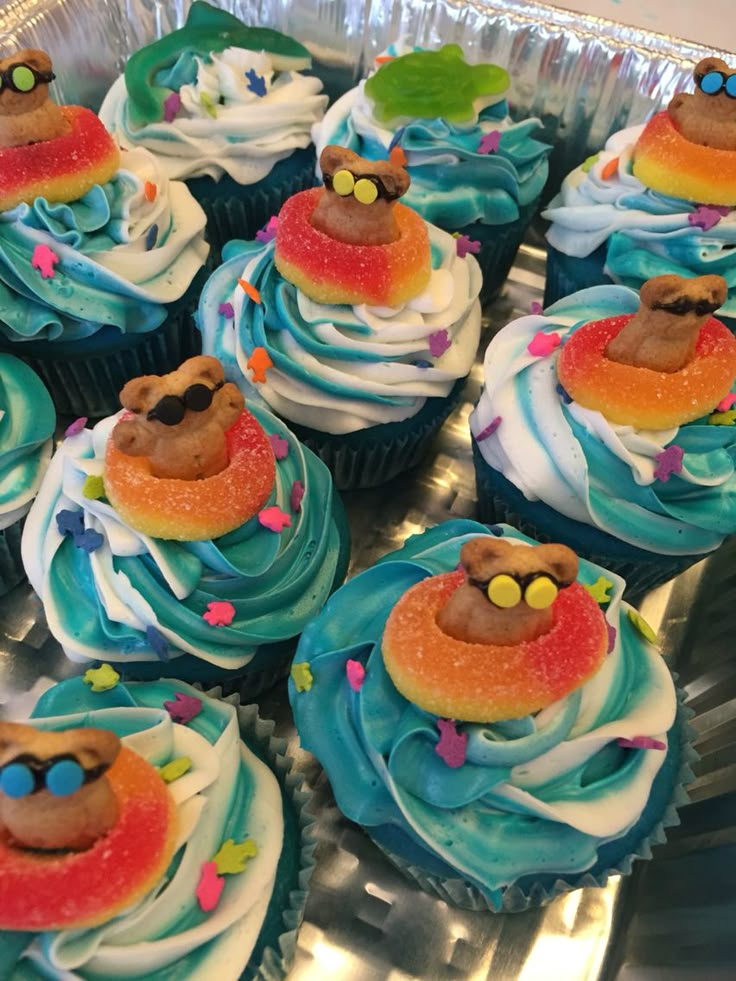 cupcakes with blue frosting and colorful decorations