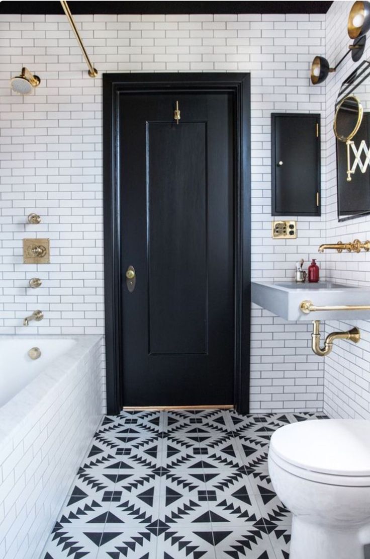 a black and white tiled bathroom with gold accents