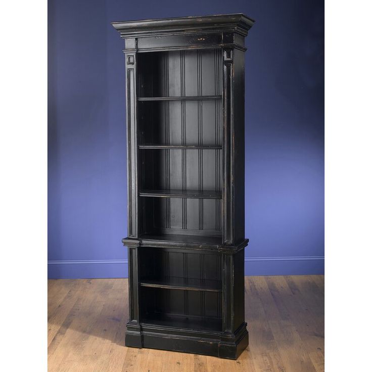 a tall black bookcase on a wooden floor in front of a blue wall with wood floors