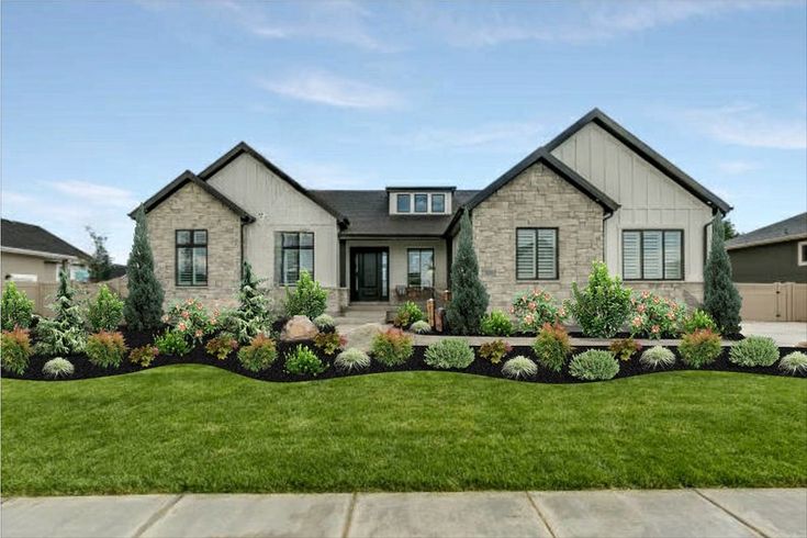 a house with landscaping in front of it and grass around the yard area on both sides