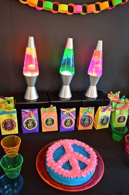 a table topped with a cake covered in frosting next to plastic cups and saucers