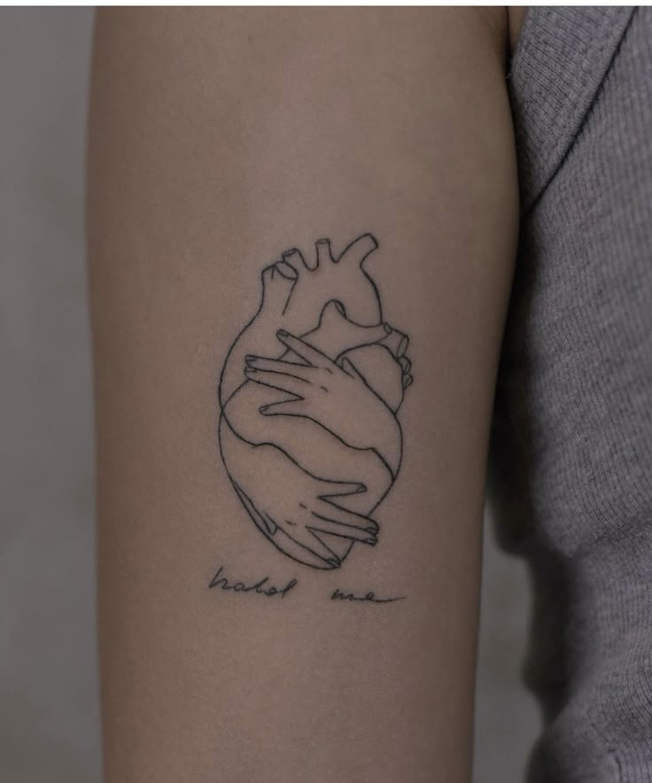 a woman's arm with a heart tattoo on it