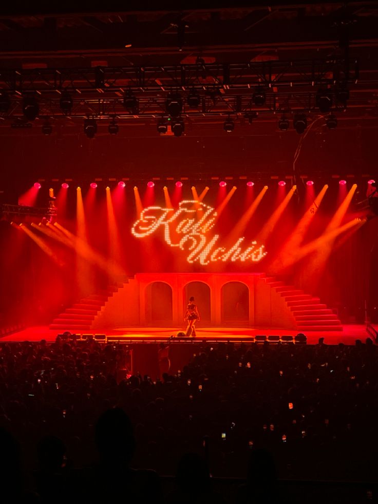 the stage is lit up with red and yellow lights as well as white lettering that reads hello world