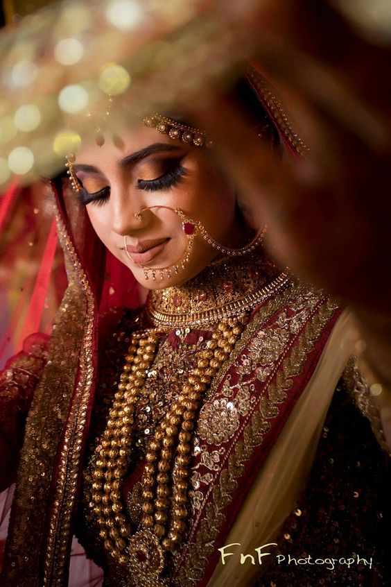 a woman in a red and gold bridal outfit