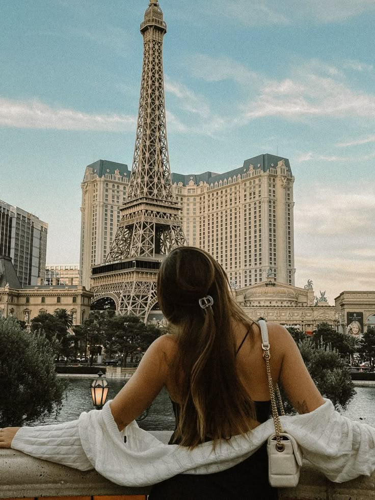 a woman looking at the eiffel tower in paris