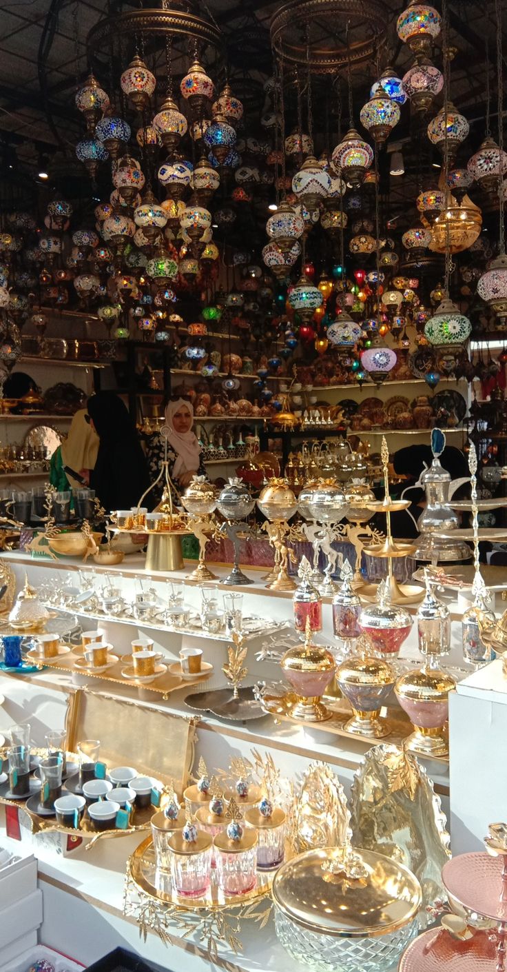 a store filled with lots of different types of glass ornaments hanging from the ceiling above