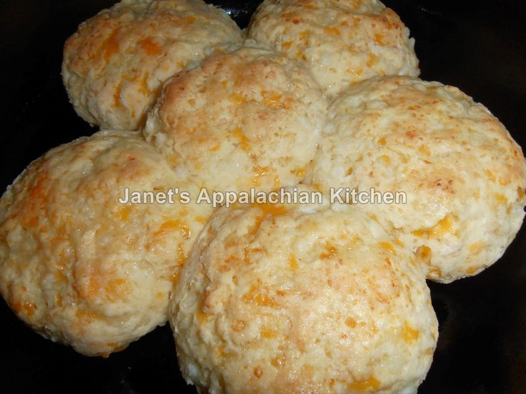 four biscuits sitting on top of a black plate