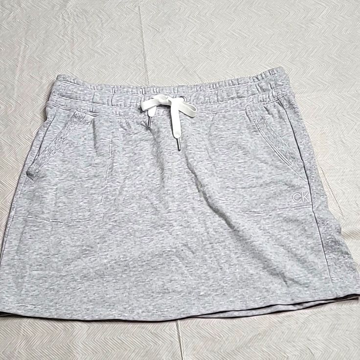 Nwt Calvin Klein Performance Super Cute, Sporty Mini Skirt Has Pockets! Light Gray In Color Size Xl Length 17in Casual Lined Mini Skirt, Casual Short Lined Mini Skirt, Casual Stretch Cotton Skirt, Casual Short Cotton Mini Skirt, Casual Short Mini Skirt, Casual Relaxed Mini Skirt, Casual Short Pleated Skirt, Casual Cotton Skort With Relaxed Fit, Casual Cotton Lined Mini Skirt