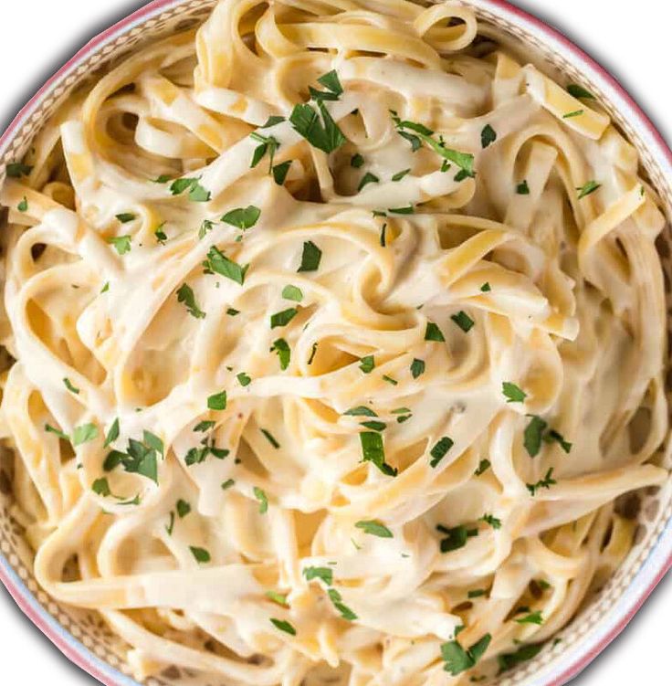 a bowl filled with pasta and topped with parsley