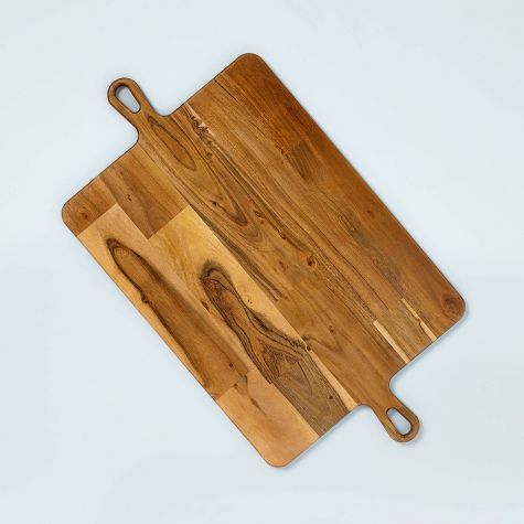 a wooden cutting board sitting on top of a white table