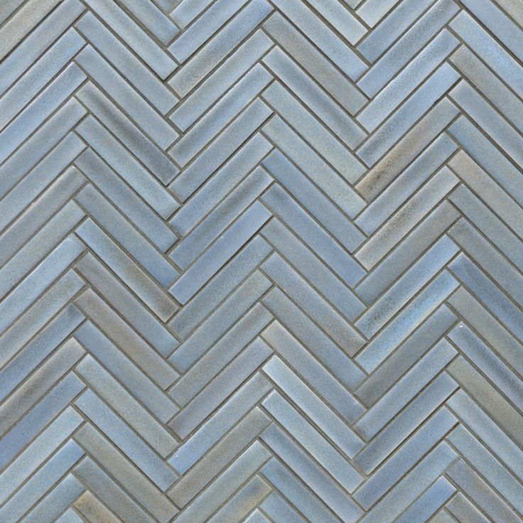 a close up view of a herringbone tile pattern in blue and grey tones,