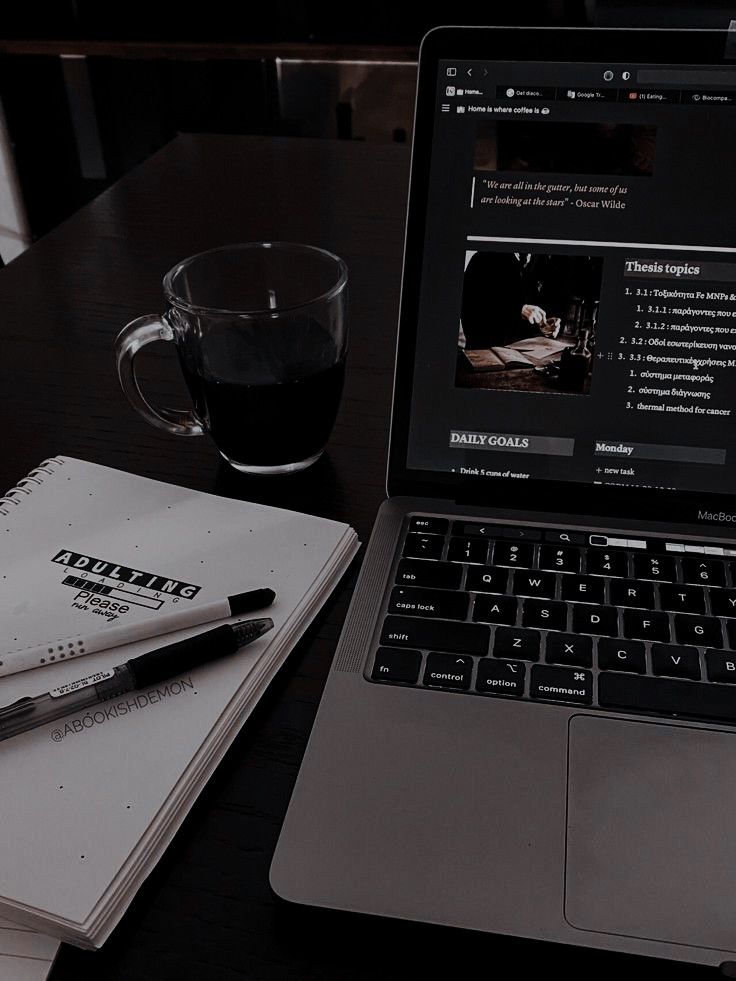 an open laptop computer sitting on top of a desk next to a cup of coffee