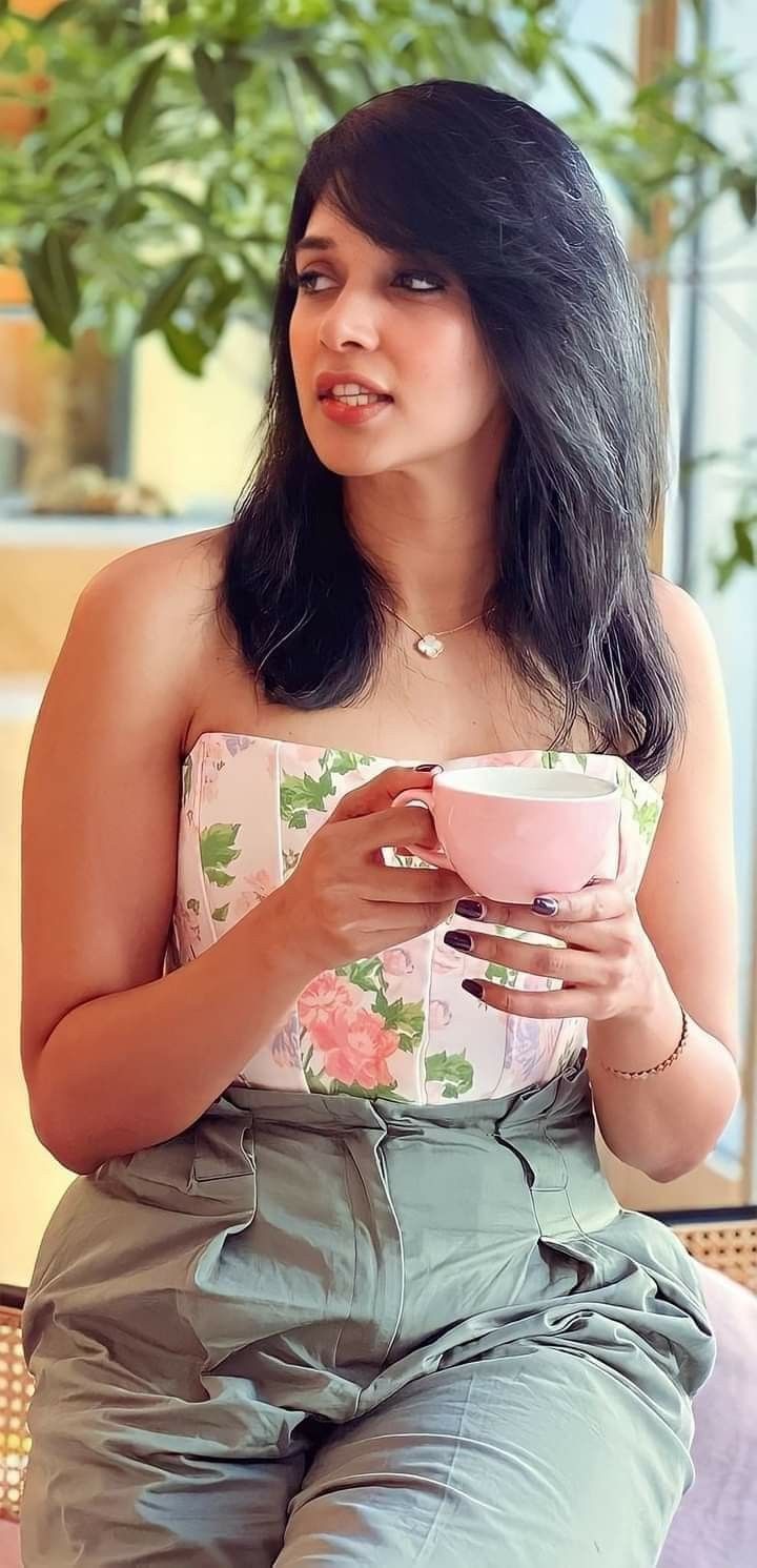 a woman sitting on a chair holding a cup