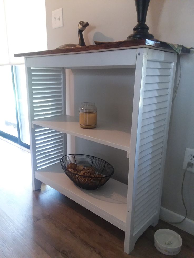 a shelf with some food on top of it and a basket in front of it