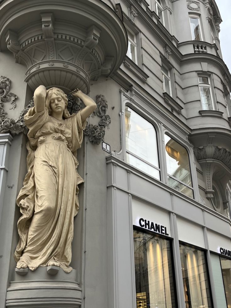 a statue on the side of a building in front of a chandelier shop