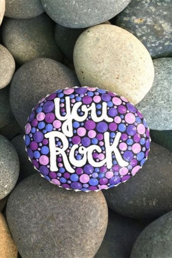 a rock with the words you rock painted on it surrounded by rocks and stones that spell out, you rock