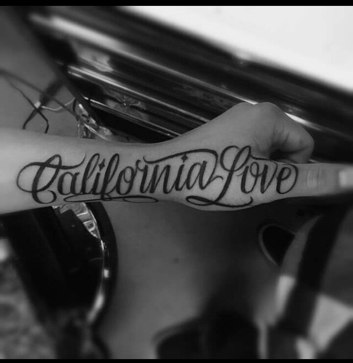 someone is holding their arm with the word california love tattooed on it