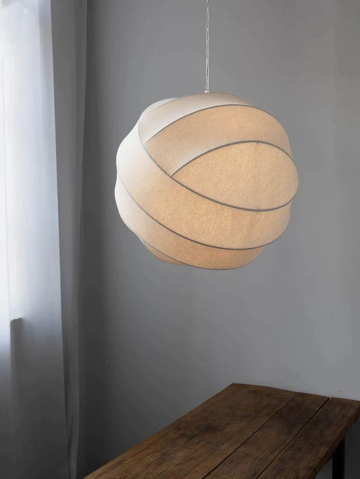 a light hanging from the ceiling over a wooden table