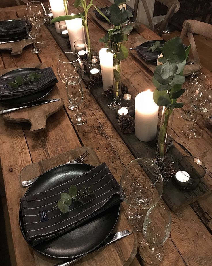 a wooden table topped with plates and candles