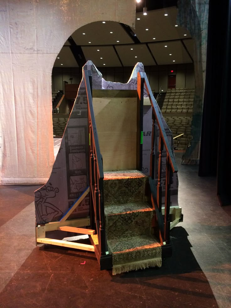 an empty stage with stairs and carpeted flooring