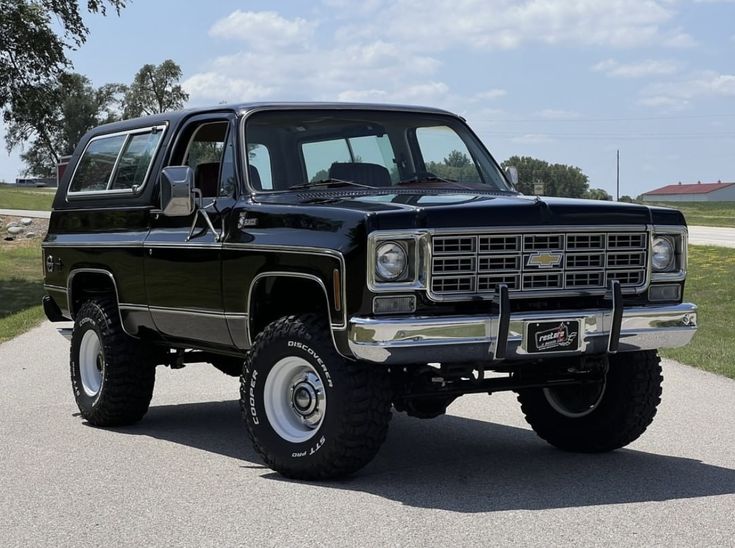 a large black truck parked on top of a road