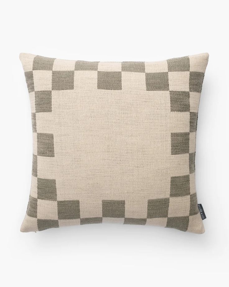 a beige and grey pillow with squares on it