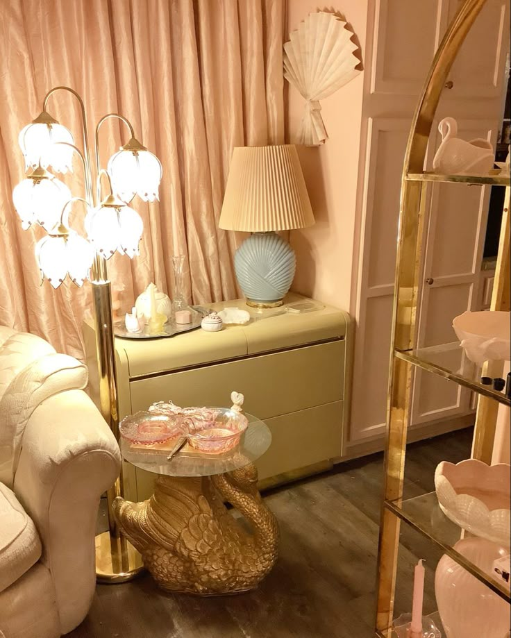 a living room filled with furniture next to a tall gold shelf and window covered in pink curtains