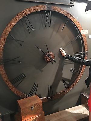 a woman standing in front of a large clock