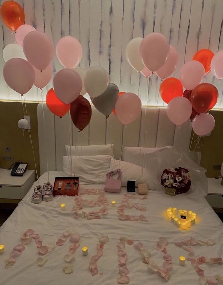 a bed topped with lots of balloons and confetti