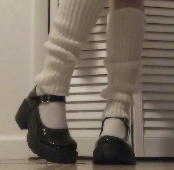 a person wearing white socks and black shoes