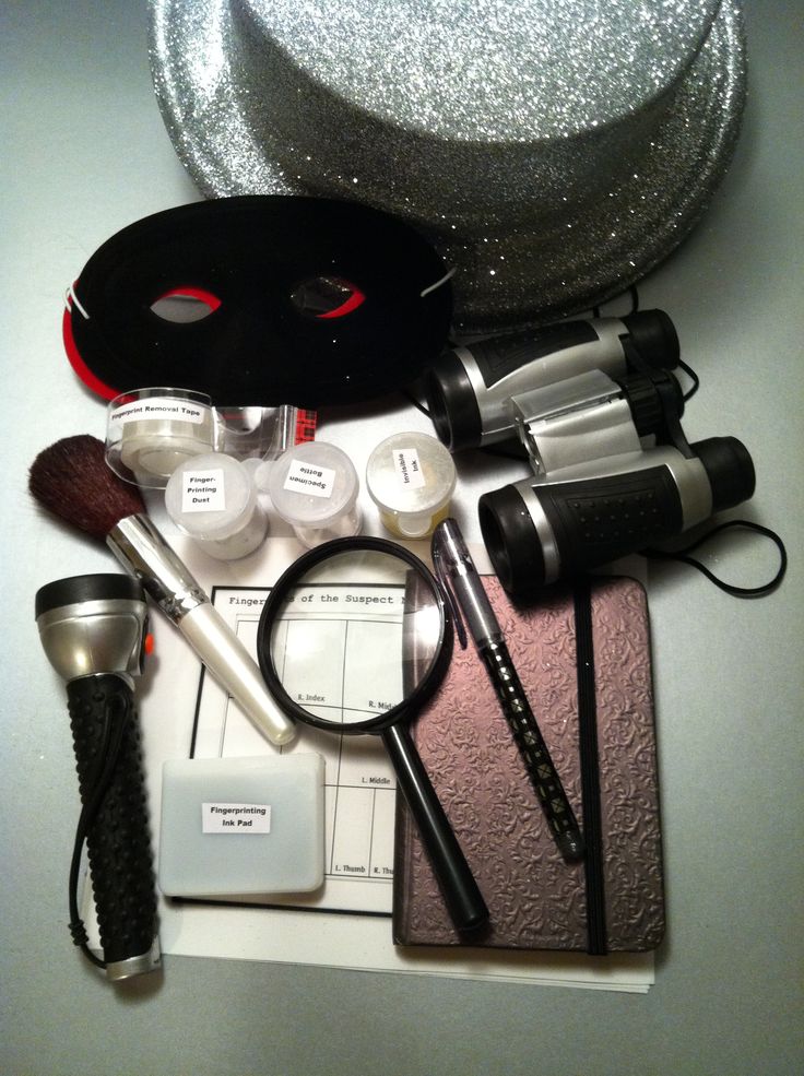 the contents of a makeup bag laid out on top of a white countertop with silver sequins