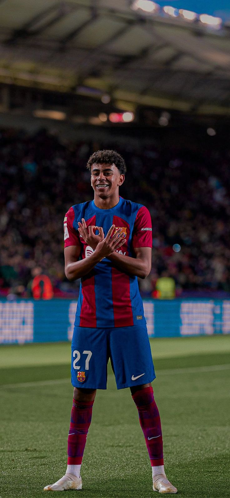 a man standing on top of a soccer field holding his hands in front of him