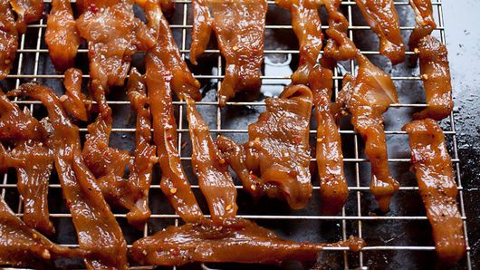 several pieces of meat sitting on top of a metal grate covered in brown sauce