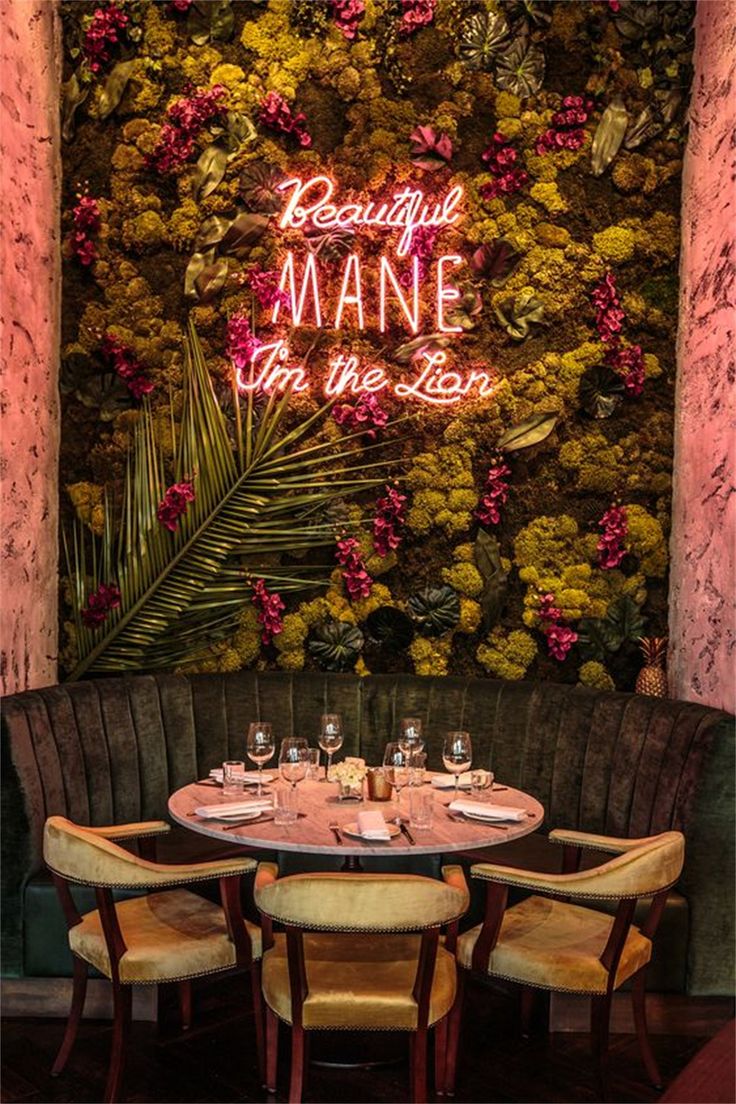 the restaurant is decorated with pink flowers and greenery, along with neon signs that read beautiful mane from the lion