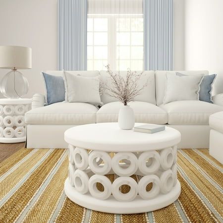 a living room with white furniture and blue curtains