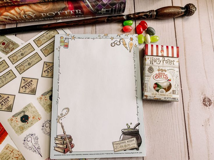 an open notebook sitting on top of a wooden table next to candy and other items