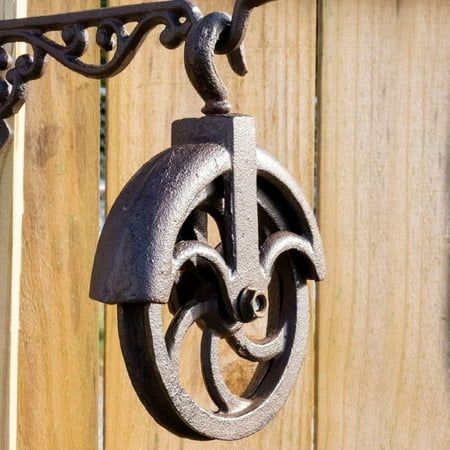 an old fashioned metal object hanging from a wooden fence